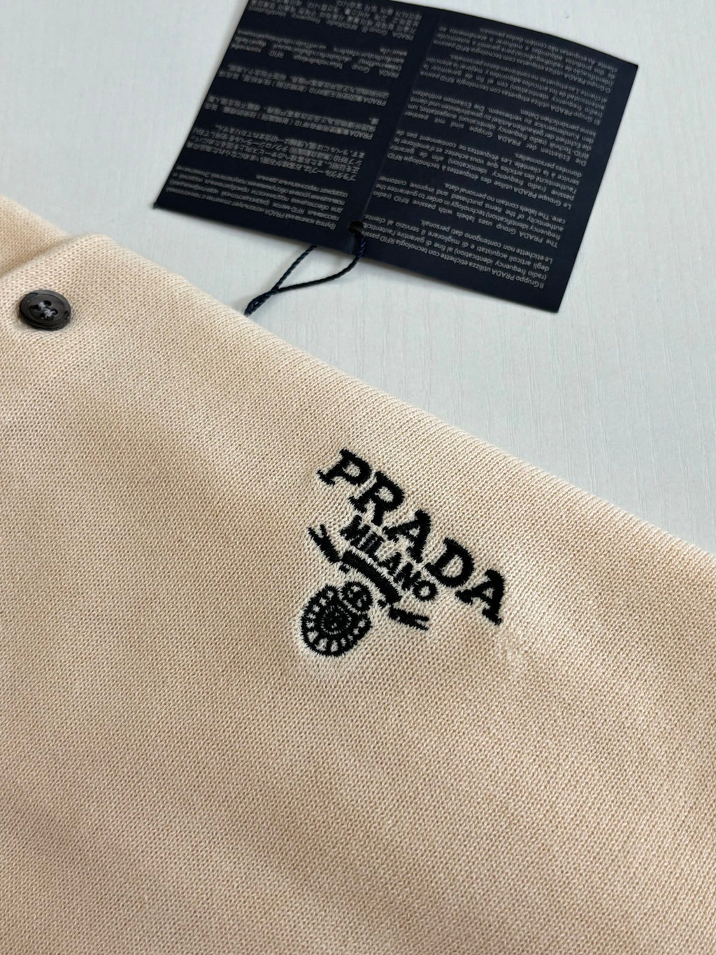 Beige polo shirt chest logo embroidery near the button placket
