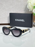 Black round sunglasses with gold-tone chain arms and tinted lenses