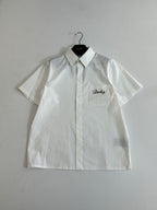 White short-sleeve button-up shirt with pointed collar and chest logo