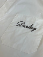 White shirt chest pocket with embroidered script logo