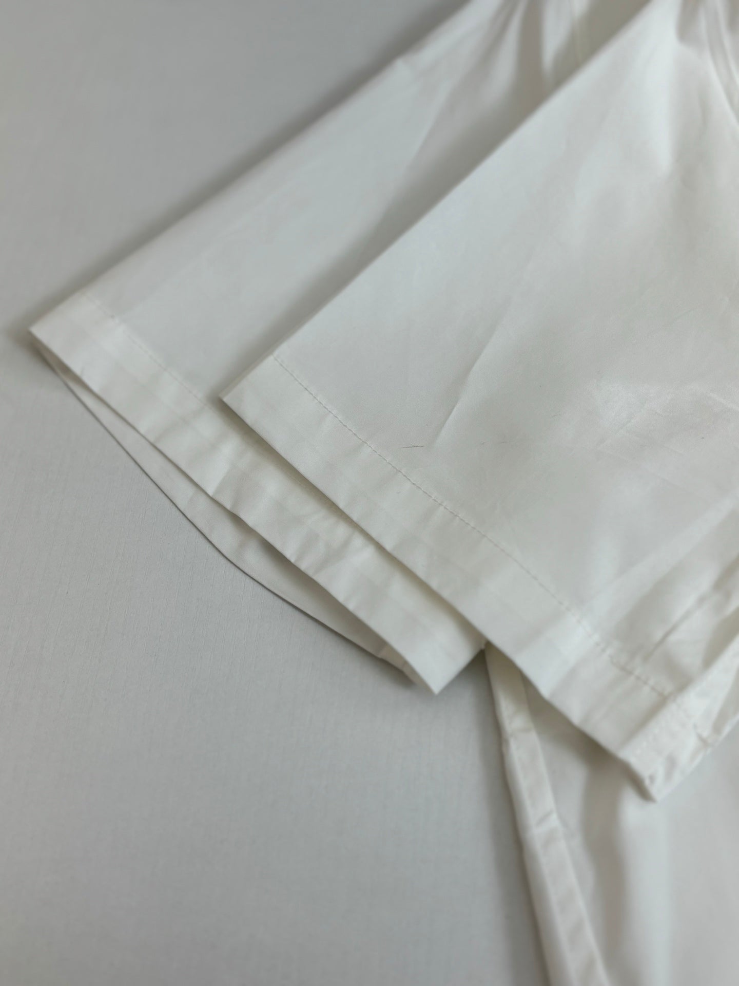 White shorts laid flat with stitched hem detail