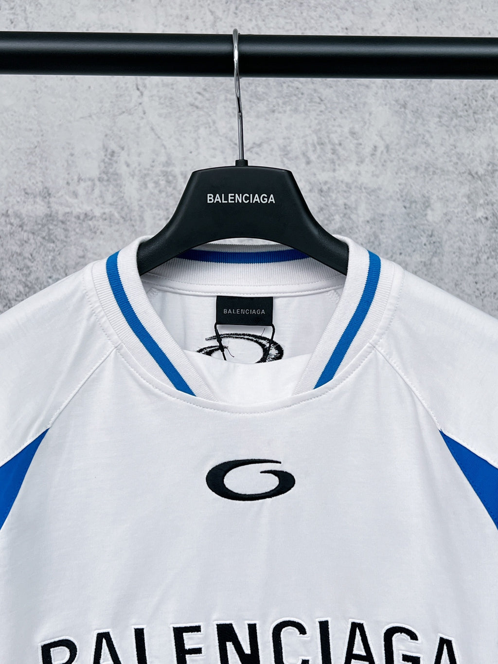 White crewneck long-sleeve T-shirt with blue collar trim and small chest logo