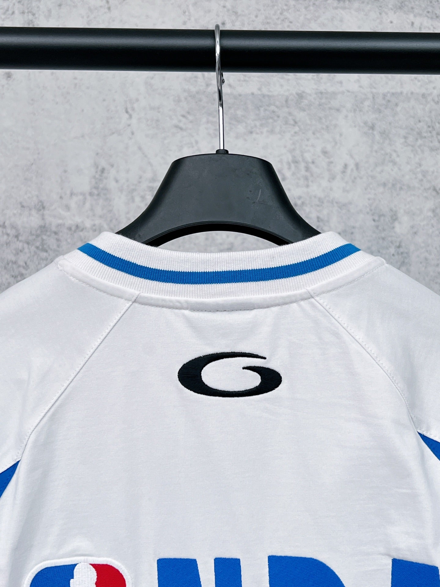 White long-sleeve T-shirt with blue-striped raglan shoulders and small back logo