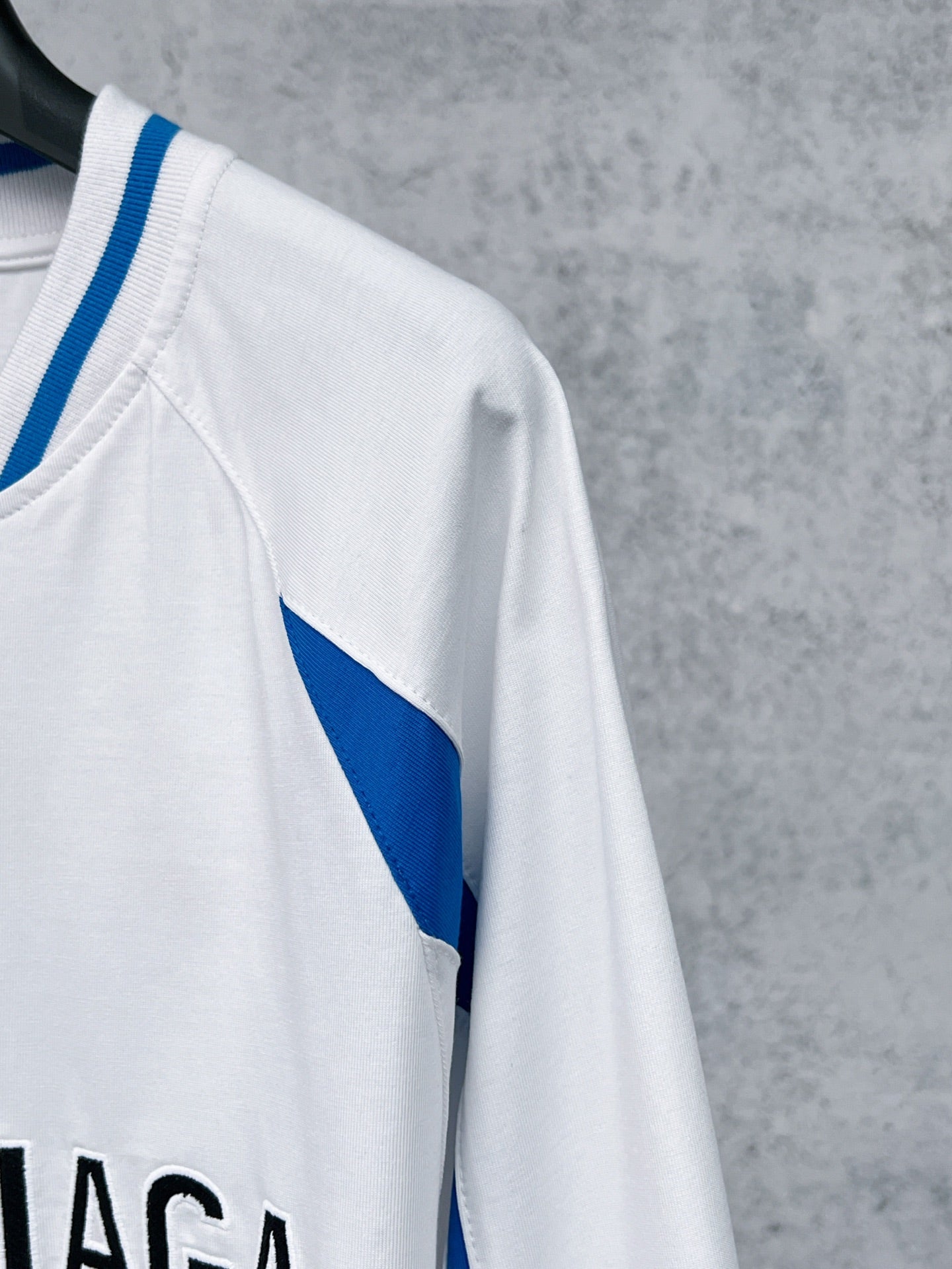 White long-sleeve T-shirt sleeve with blue diagonal stripe panel
