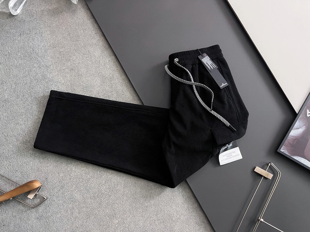Black cargo pants laid flat with drawstring waistband and visible tags