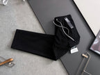 Black cargo pants laid flat with drawstring waistband and visible tags