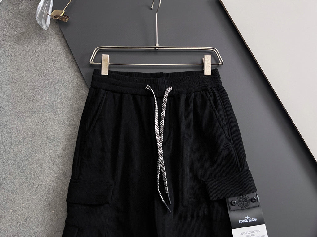 Black cargo pants front view with elastic waistband, drawstring and side pocket patch