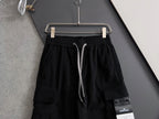 Black cargo pants front view with elastic waistband, drawstring and side pocket patch