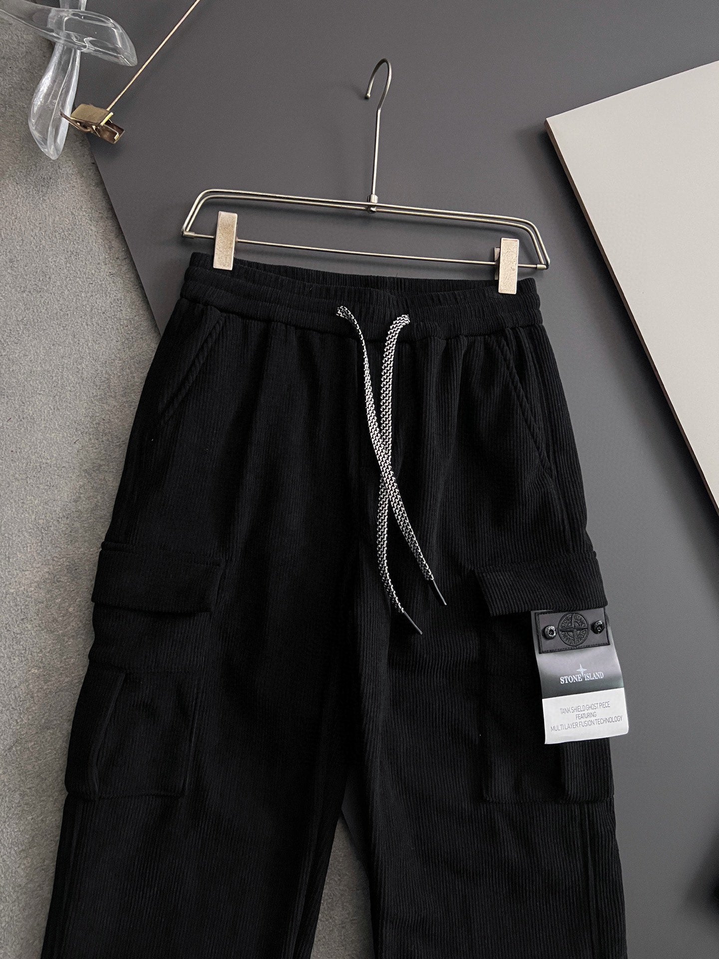 Black cargo pants with drawstring and side cargo pocket, sewn fabric label