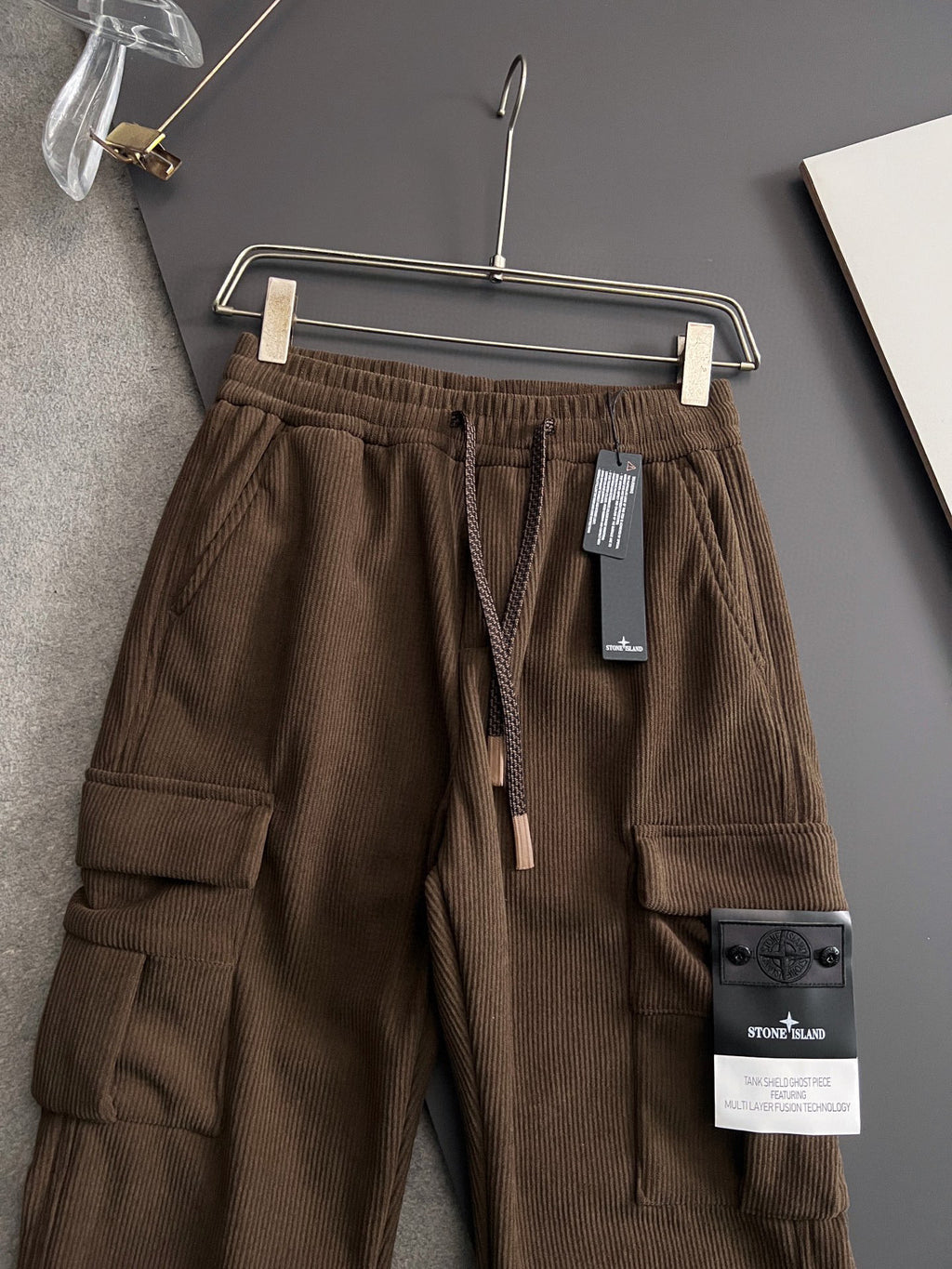 Brown cargo pants with cargo pockets, elastic waistband, and drawstring ties