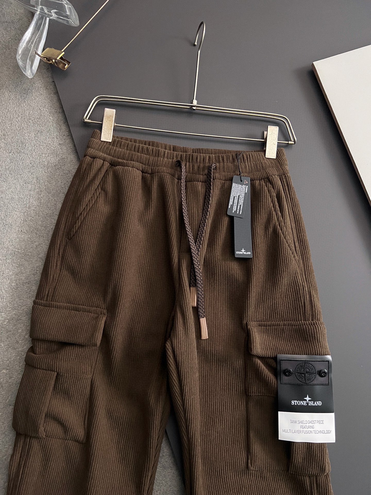 Brown cargo pants with cargo pockets, elastic waistband, and drawstring ties