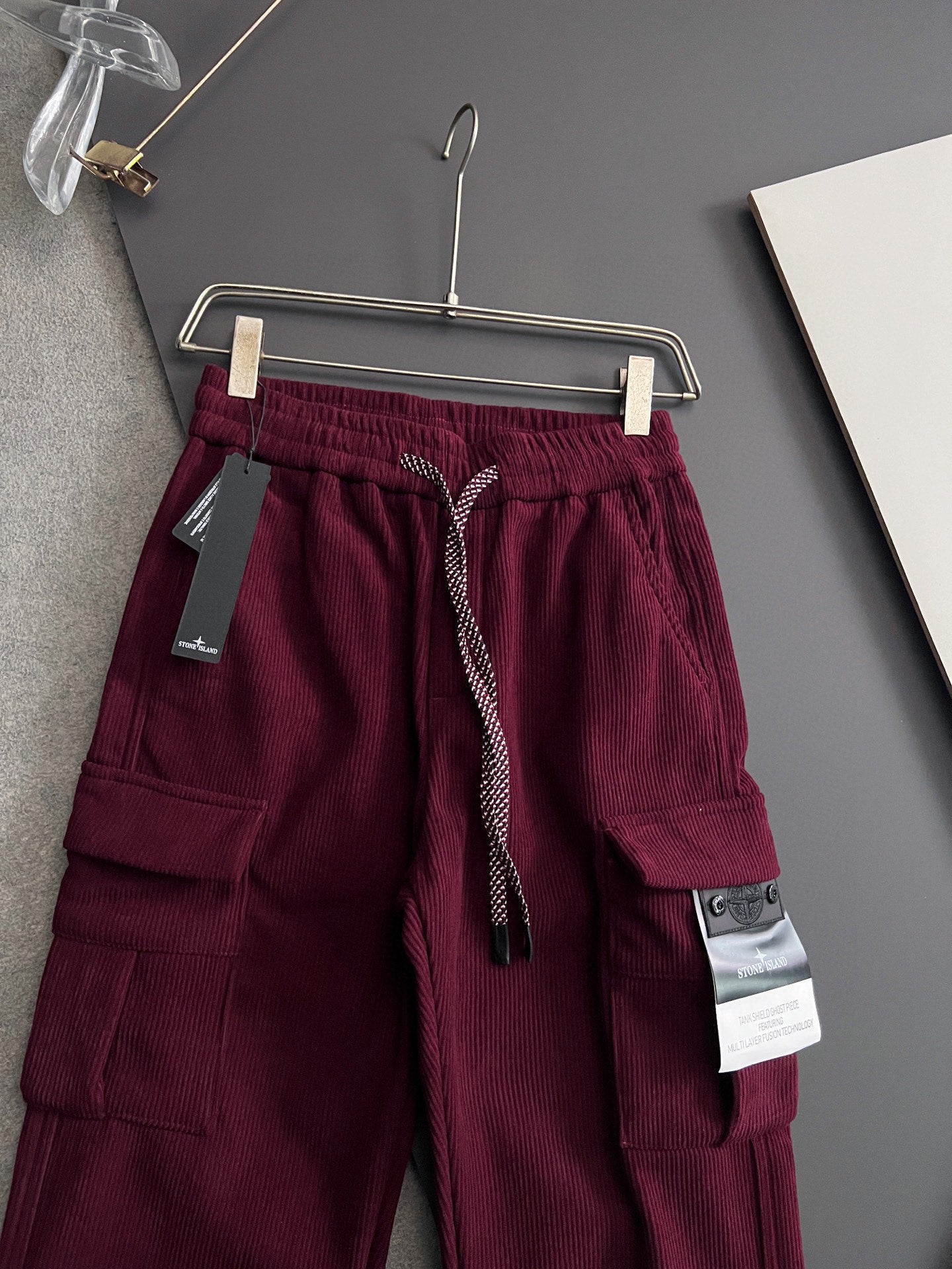 Burgundy cargo pants on hanger with elastic waistband and drawstring