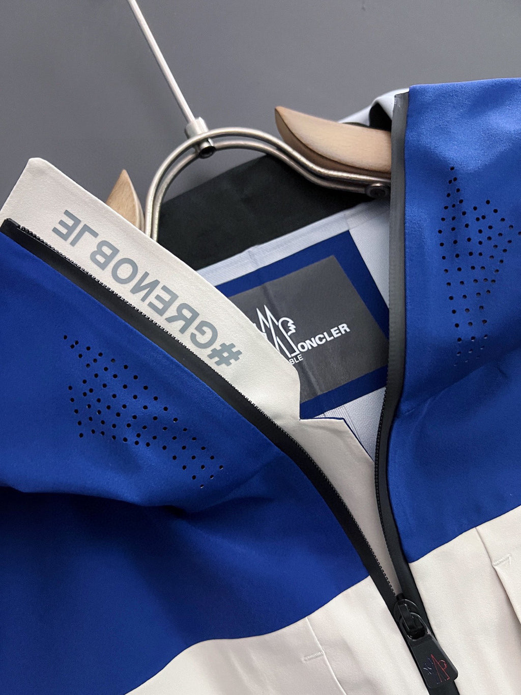 Moncler hooded jacket collar detail, blue and white panels with logo label