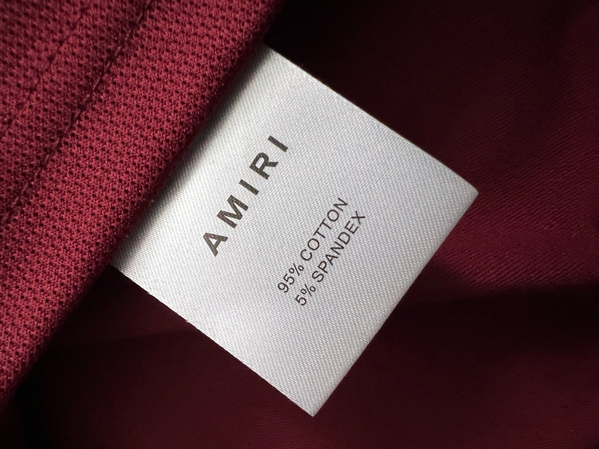 Inside neck tag showing AMIRI and 95% cotton, 5% spandex