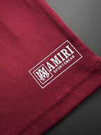 Burgundy fabric tag patch with AMIRI and SPORTSH?EART branding and logo