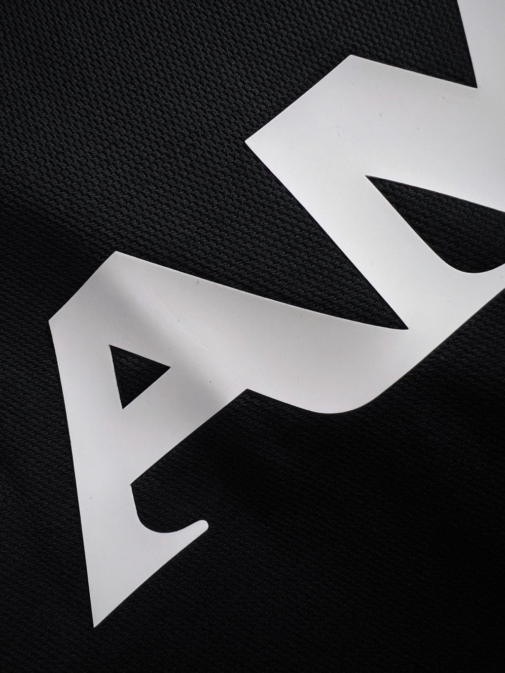 Black T-shirt fabric with large white AMIRI lettering
