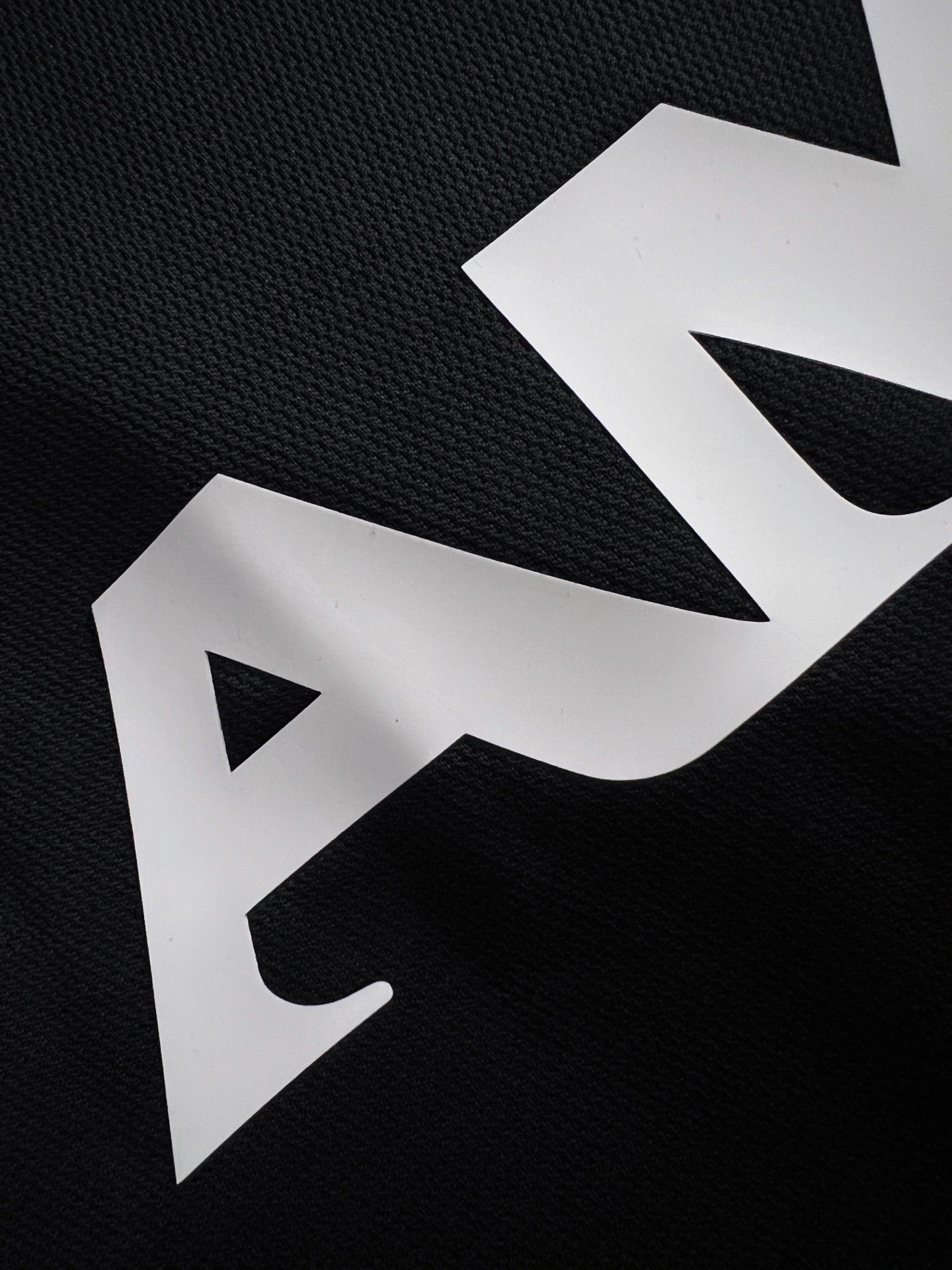 Black T-shirt fabric with large white AMIRI lettering