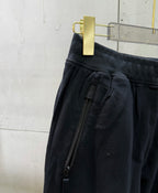 Black cargo pants detail: zip pocket and gathered waistband