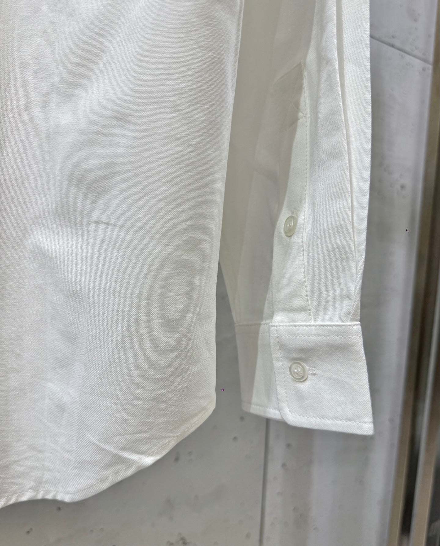 White shirt cuff with button placket and folded sleeve