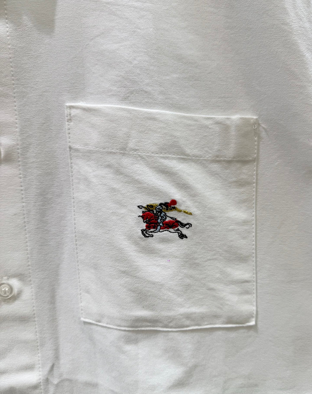 White shirt pocket with multicolor embroidered horse crest