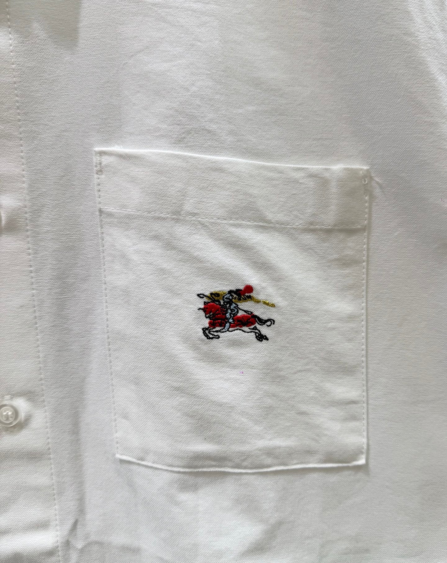 White shirt pocket with multicolor embroidered horse crest