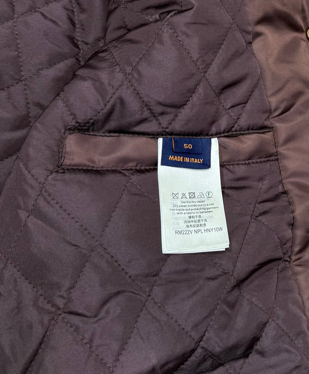 Quilted burgundy bomber jacket interior with size and care label tag