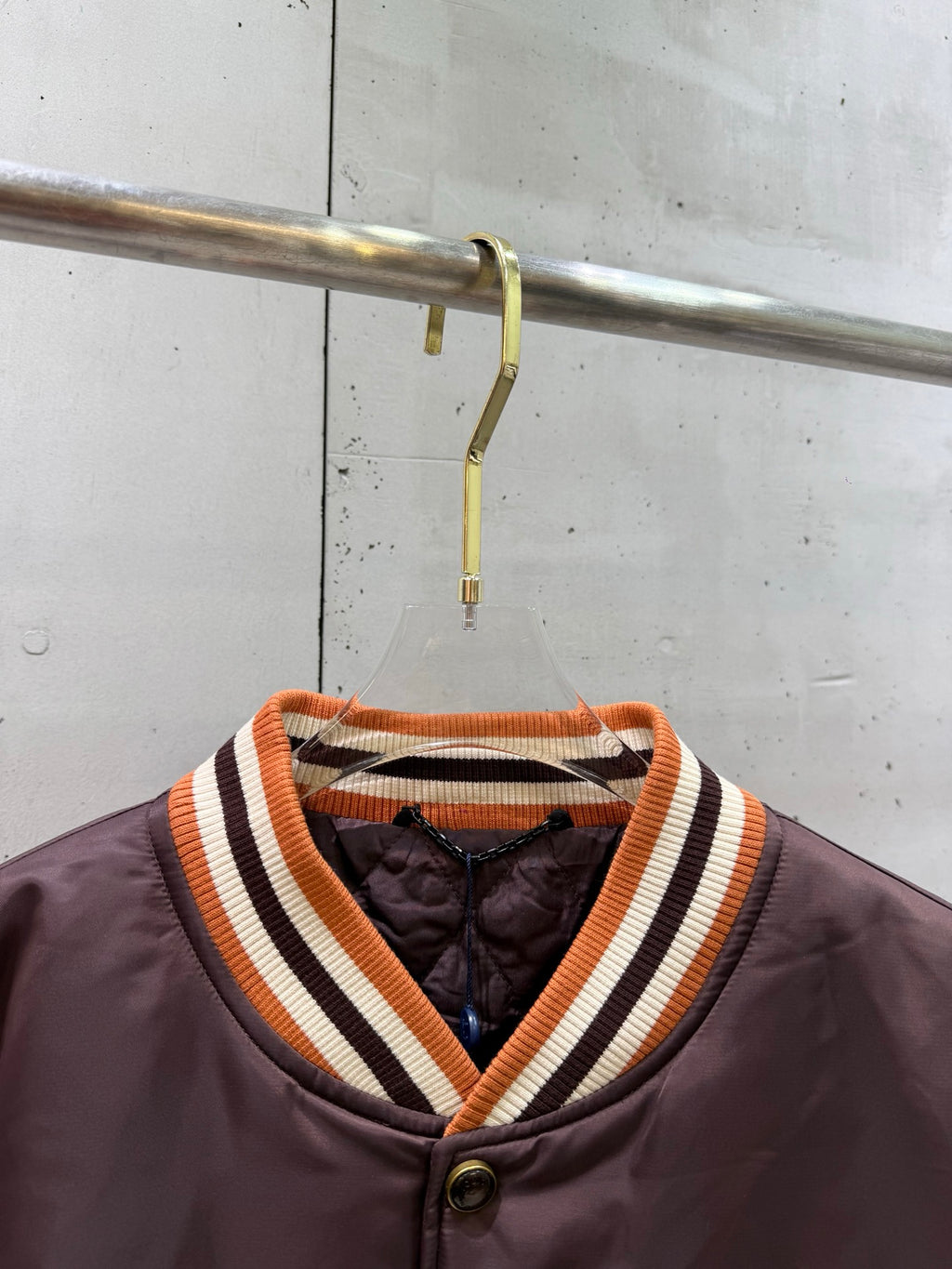 Burgundy bomber jacket with striped ribbed V-neck collar and button placket