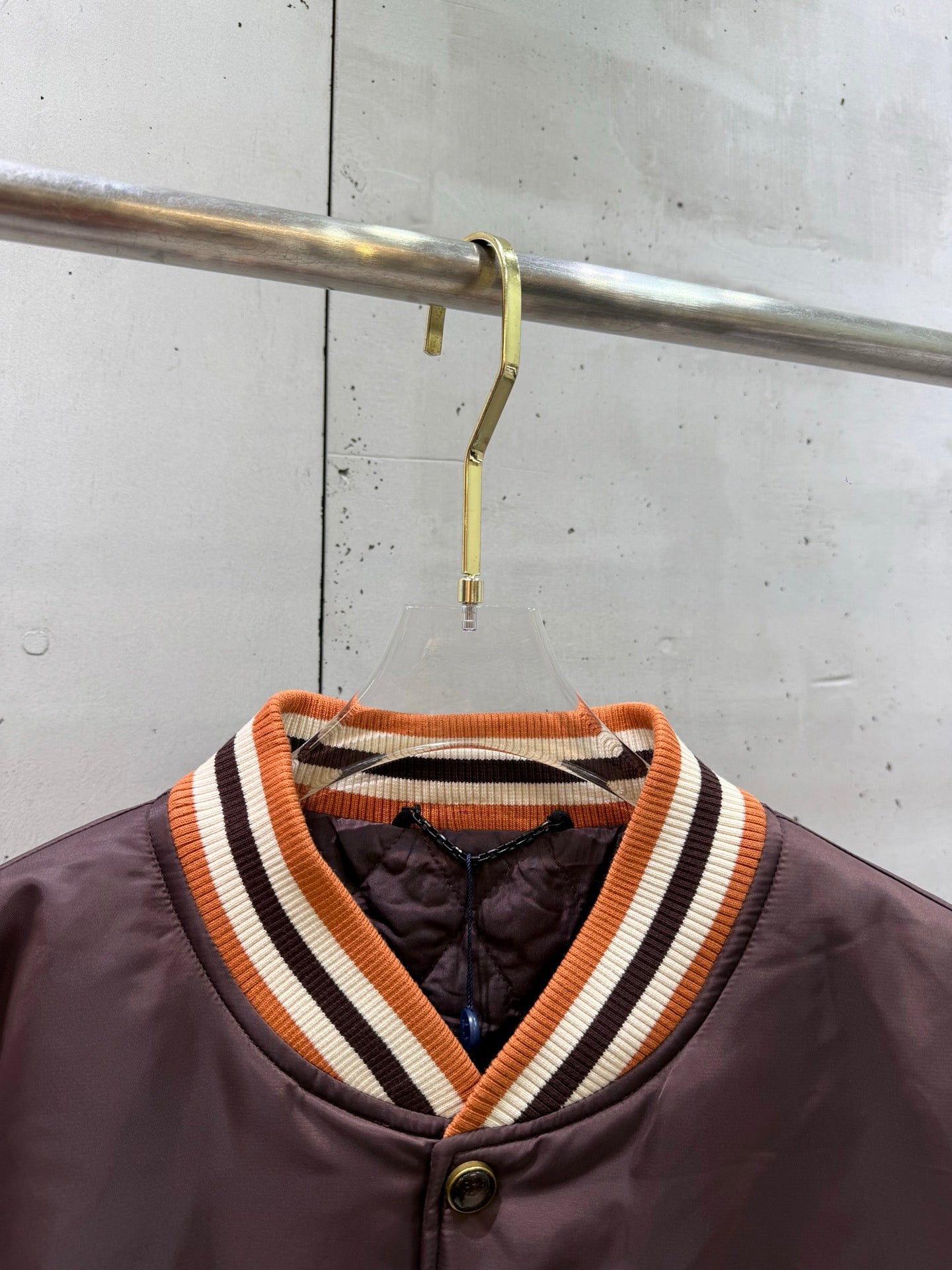 Burgundy bomber jacket with striped ribbed V-neck collar and button placket