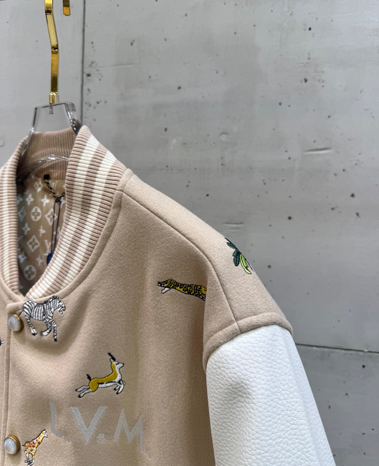 Louis Vuitton jacket side view with animal embroidery and contrasting textured white sleeves.