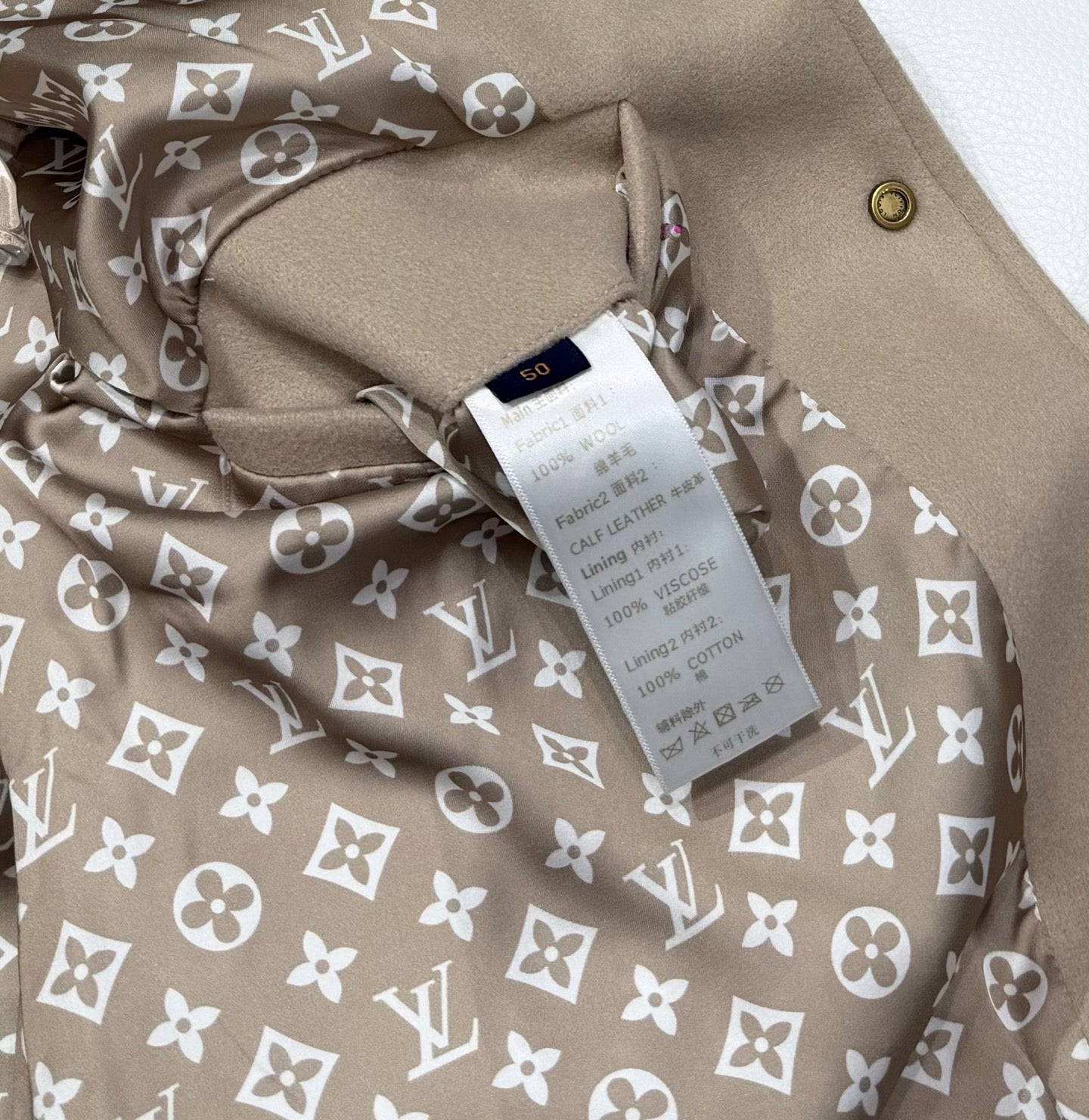 Louis Vuitton jacket inside lining with beige base and white monogram floral pattern.