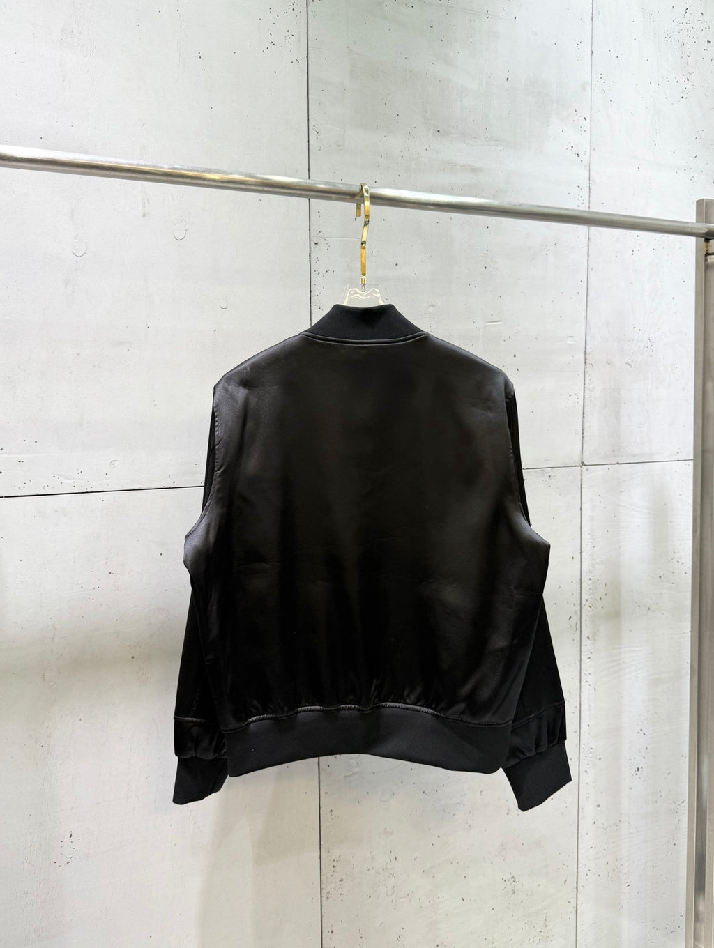 Black bomber jacket back with ribbed hem and cuffs