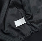 Black bomber jacket fabric close-up with inner label tag