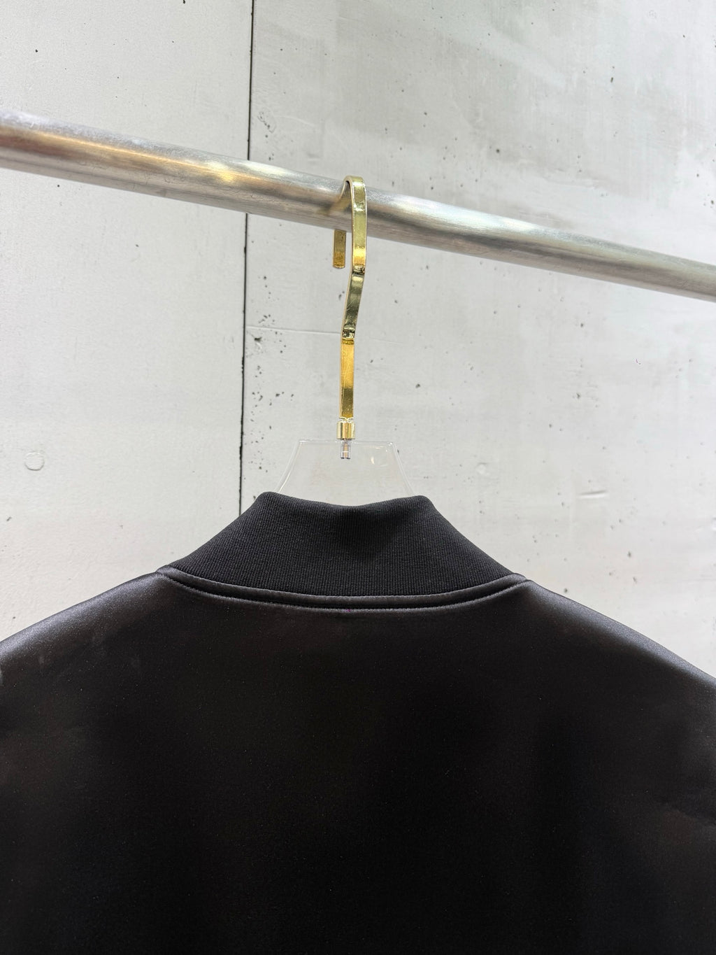 Black bomber jacket back with ribbed collar and smooth satin-like finish