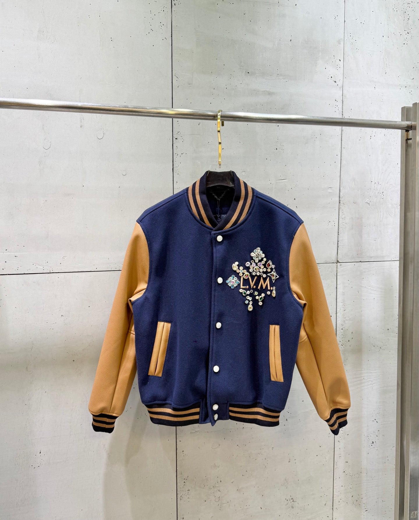 Louis Vuitton varsity jacket, navy body with tan sleeves and snap front