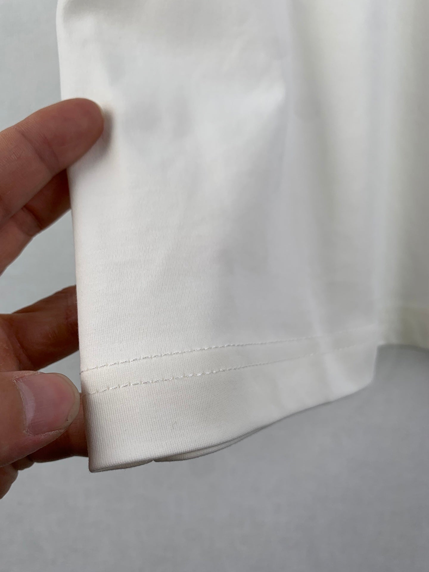 White T-shirt hem seam with stitched bottom edge detail