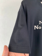Dark gray T-shirt sleeve hem detail with front graphic partially visible
