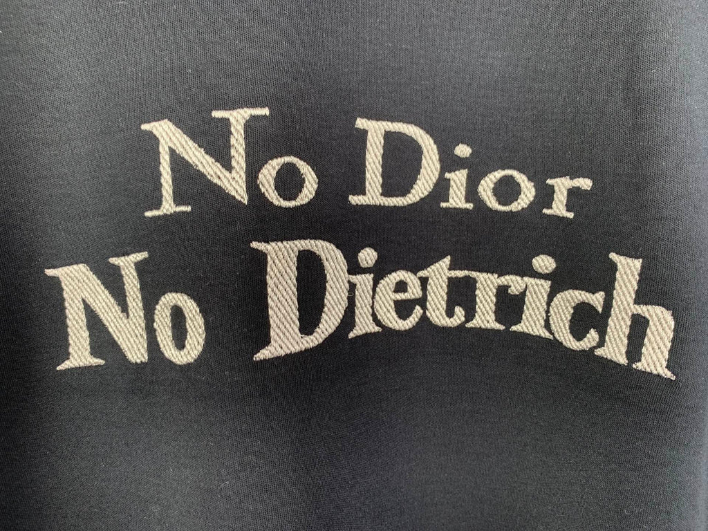 Dark gray T-shirt with large gold “No Dior No Dietrich” lettering