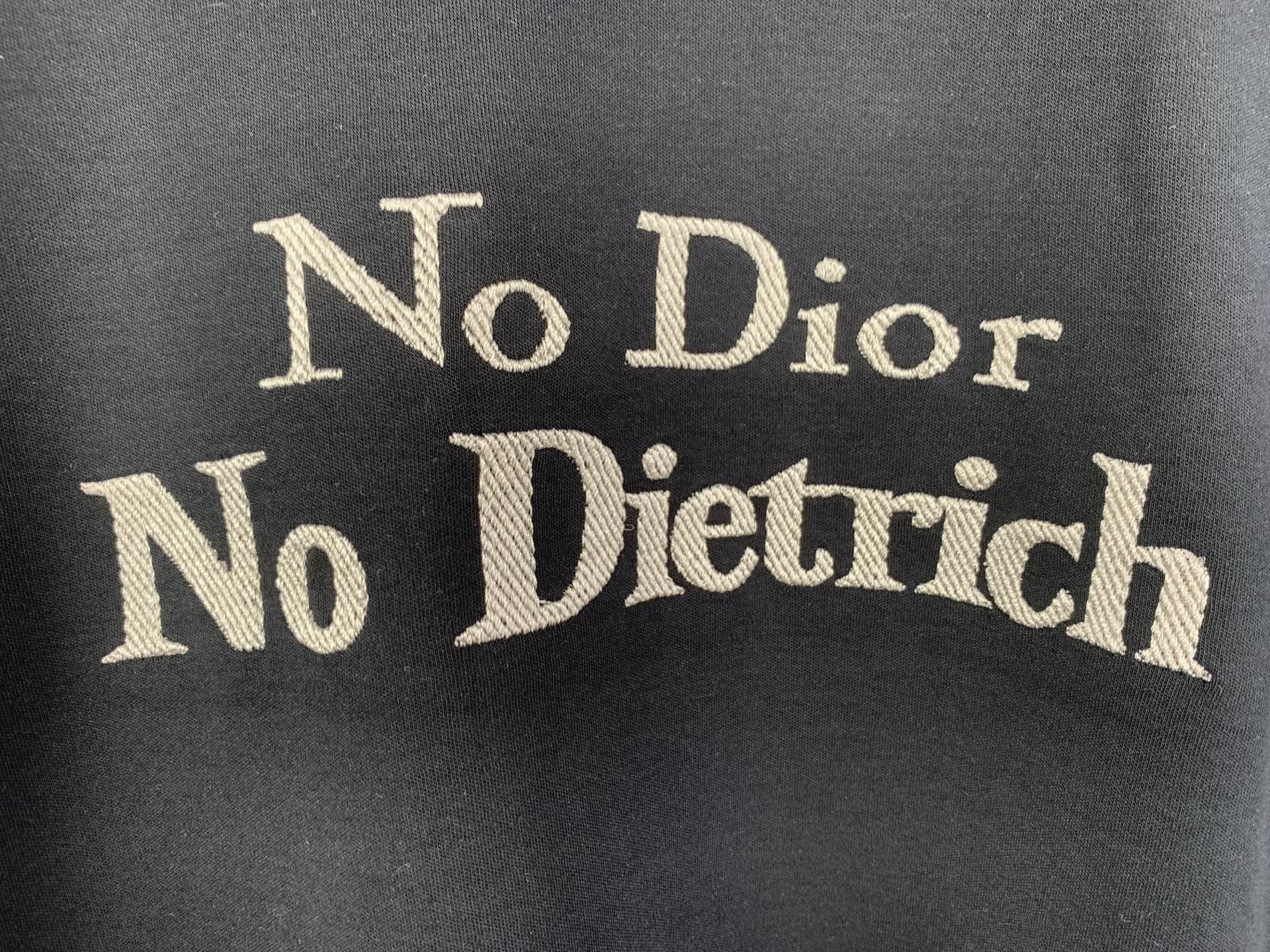 Dark gray T-shirt with large gold “No Dior No Dietrich” lettering