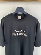 Dark gray T-shirt front close-up with “No Dior No Dietrich” graphic