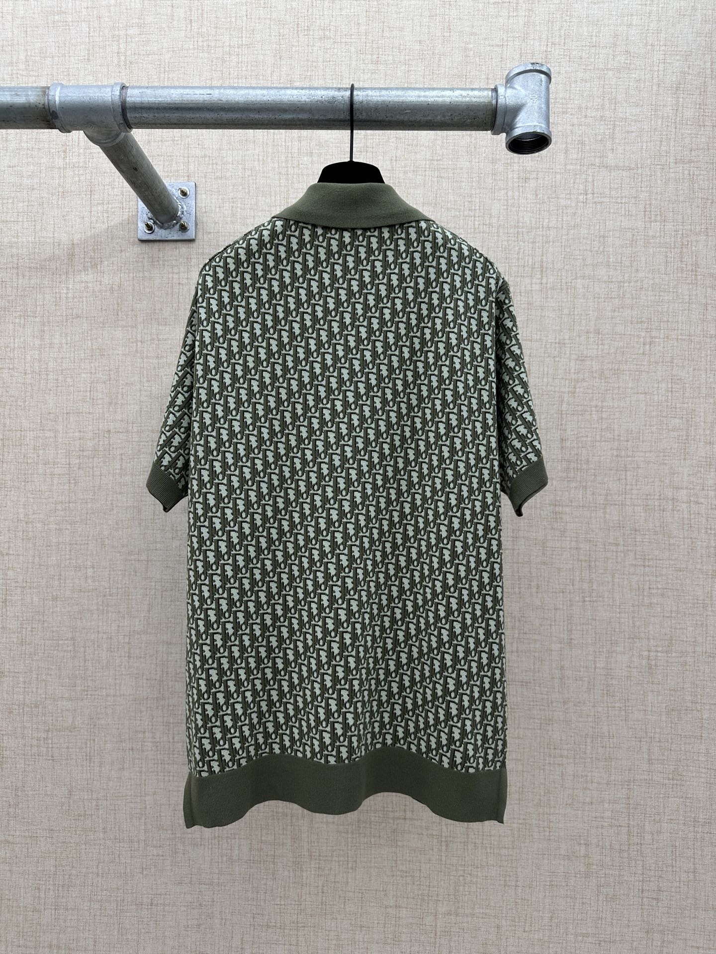 Dark green short-sleeve polo shirt back view with logo-style repeat print