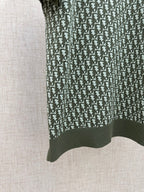 Dark green short-sleeve polo with vertical logo repeat and ribbed hem
