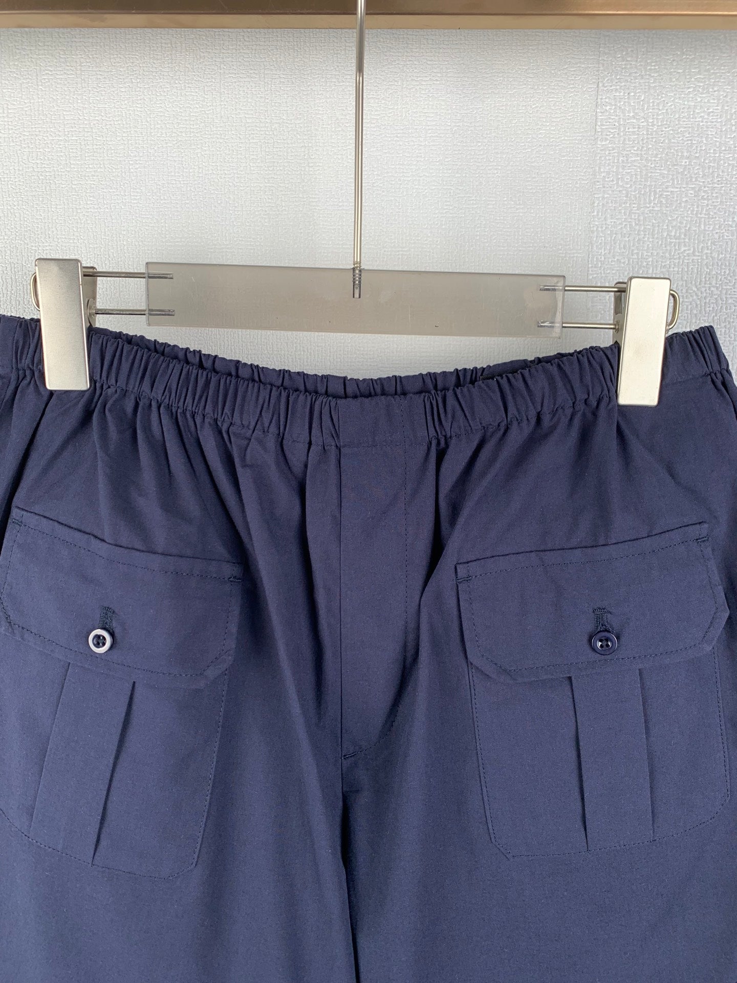 Navy Prada shorts with elastic waistband and button cargo pockets