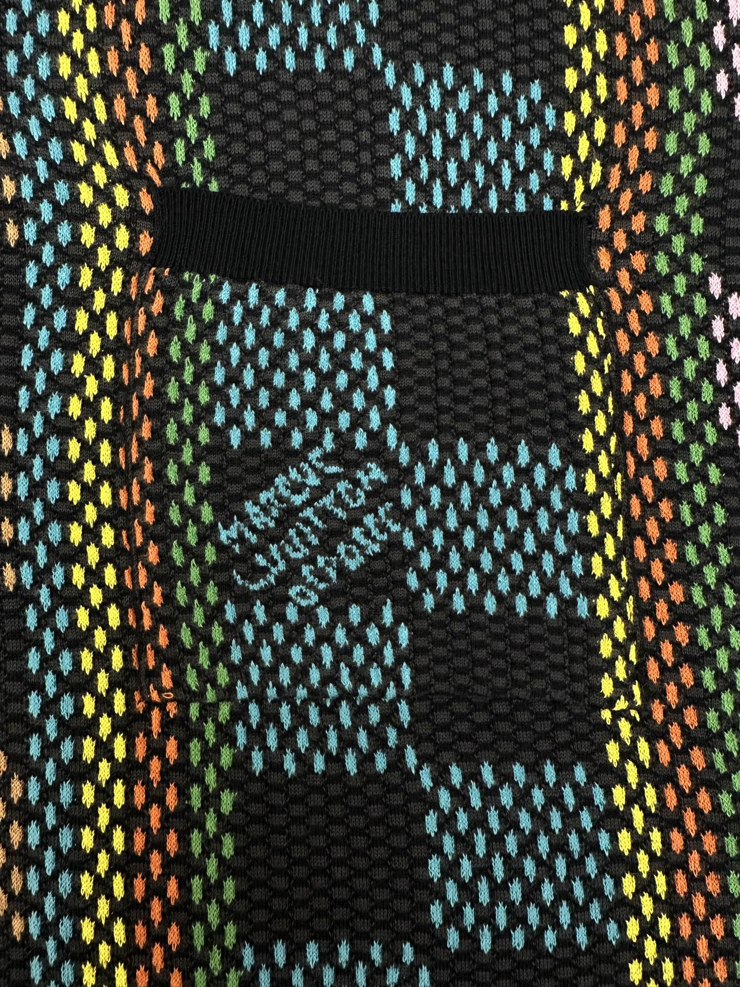 Multicolor checkered chest pocket detail on dark button-up shirt