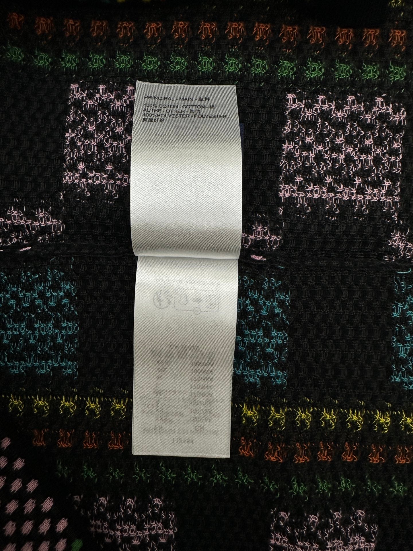 Black knit shirt with white care label and size information tag