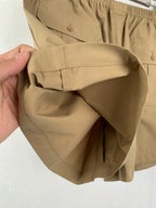 Olive shorts held open, showing front pocket opening and waistband