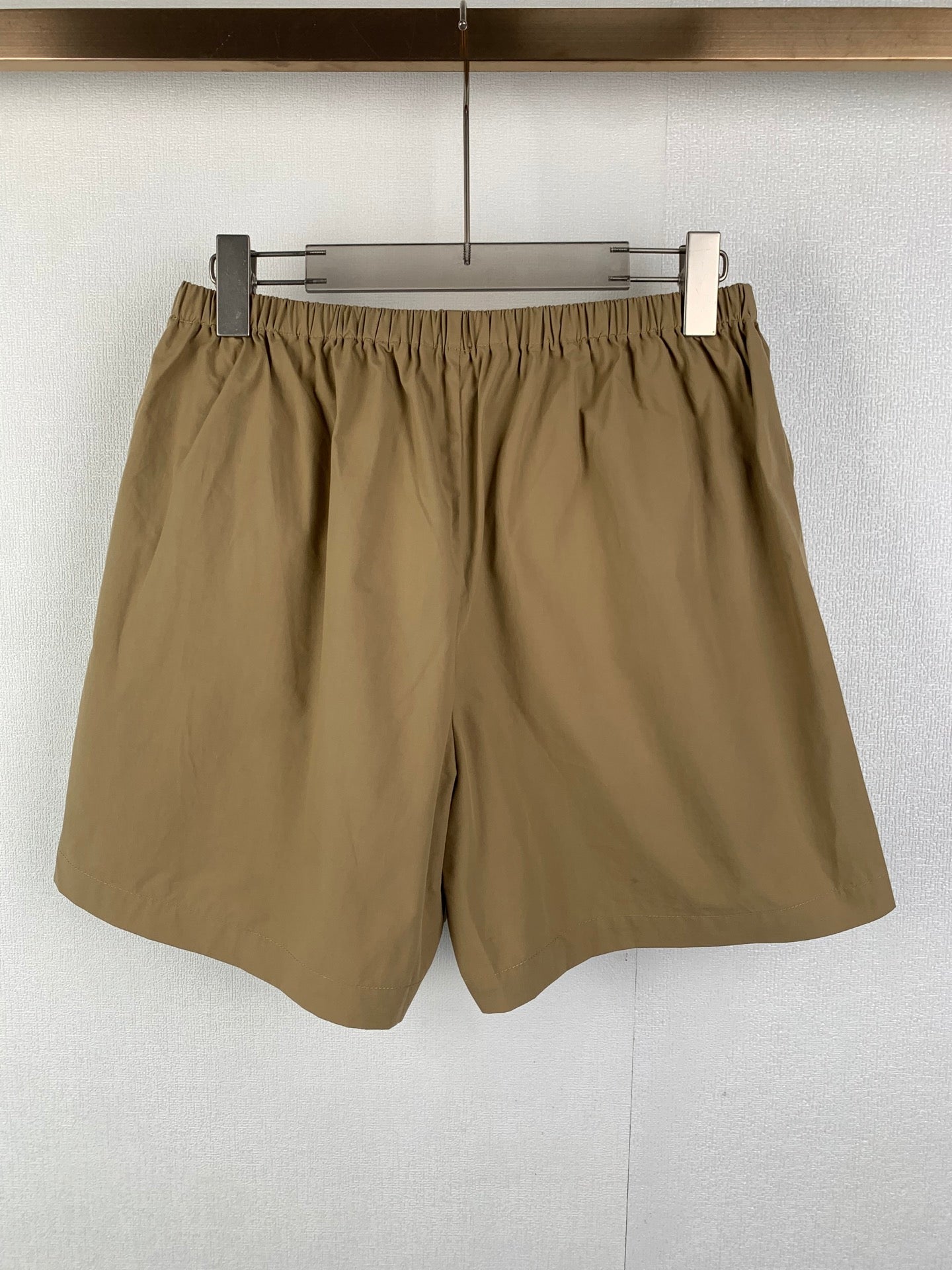 Olive elastic-waist shorts with loose fit and curved hem