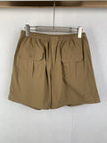 Olive drawstring shorts with elastic waistband and two front flap patch pockets