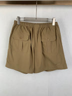 Olive drawstring shorts with elastic waistband and two front flap patch pockets