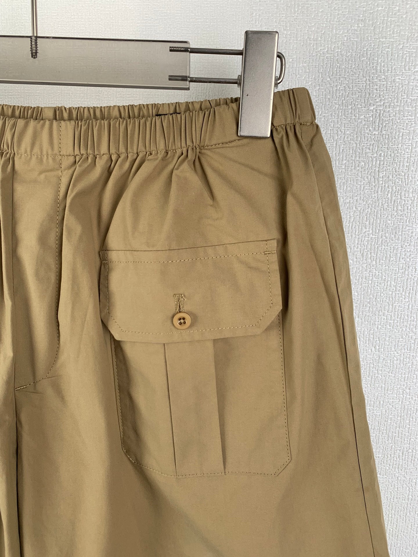 Olive shorts with single front flap patch pocket and button detail