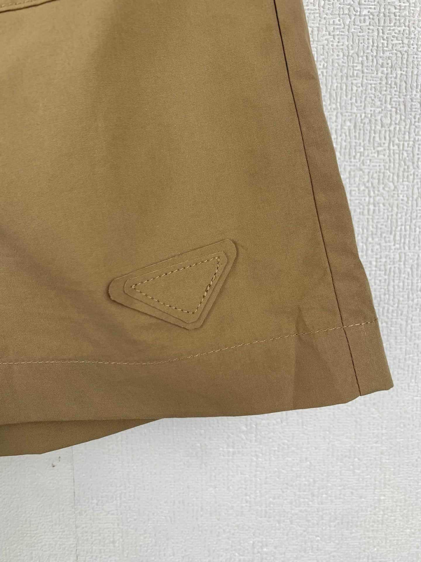 Olive shorts with stitched pocket flap detail on side seam